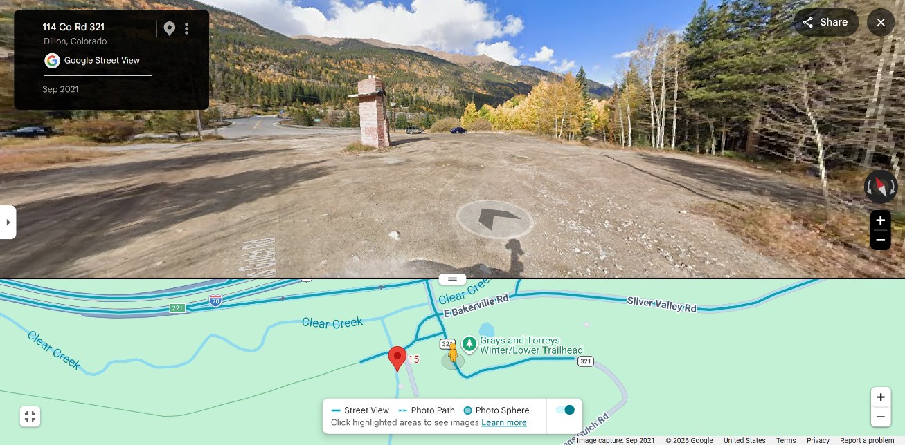 Gravel lot with cafe location marker and tree line